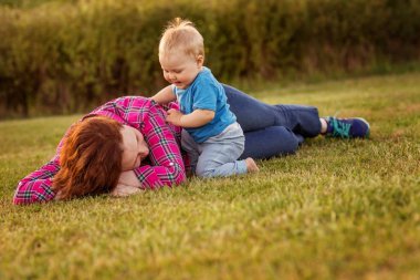 Annesi ile çim üzerinde oynayan bebek eğlence.