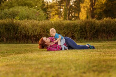 Bebek annesiyle çimenlerin üzerinde oynarken ilk yıl.