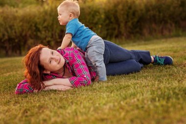 Bebek annesiyle çimenlerin üzerinde oynarken ilk yıl.