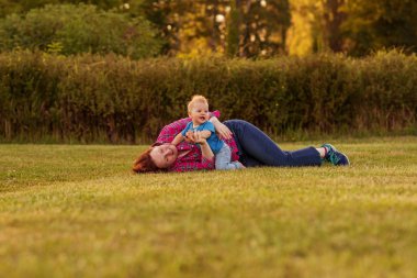 Bebek annesiyle çimenlerin üzerinde oynarken ilk yıl.