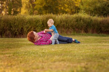 Bebek annesiyle çimenlerin üzerinde oynarken ilk yıl.