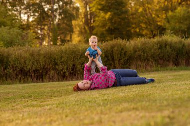 Bebek annesiyle çimenlerin üzerinde oynarken ilk yıl.