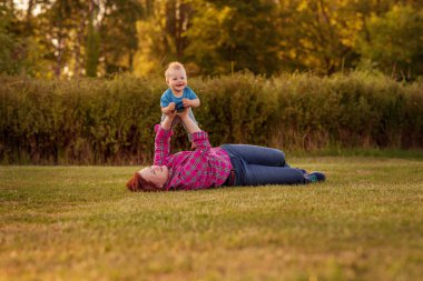 Annesi ile çim üzerinde oynayan bebek eğlence.