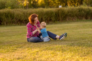 Bebek annesiyle çimenlerin üzerinde oynarken ilk yıl.