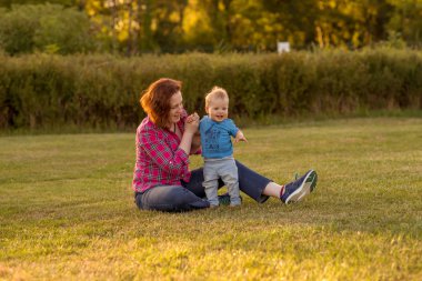 Bebek annesiyle çimenlerin üzerinde oynarken ilk yıl.