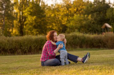 Bebek annesiyle çimenlerin üzerinde oynarken ilk yıl.