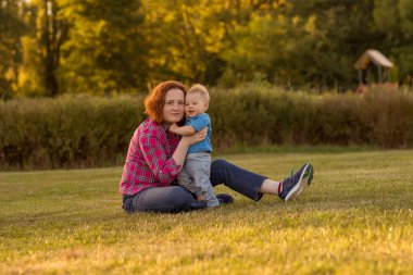 Bebek annesiyle çimenlerin üzerinde oynarken ilk yıl.
