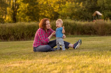 Bebek annesiyle çimenlerin üzerinde oynarken ilk yıl.