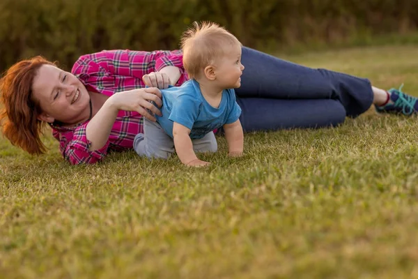 Bebek annesiyle çimenlerin üzerinde oynarken ilk yıl.