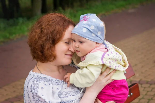 Mother Hugs Baby Sitting Bench Park — Stock Photo, Image