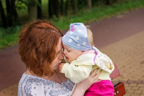 Mother Hugs Baby Sitting Bench Park — Stock Photo, Image