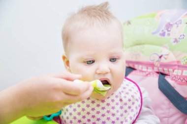 Bebek bir kaşık gelen yemeyi öğrenir. Bebeğin ilk yem.