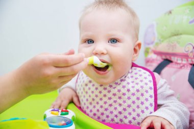 Bebek bir kaşık gelen yemeyi öğrenir. Bebeğin ilk yem.