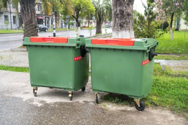 Büyük yeşil kapsayıcılar sokakta geri dönüşüm.