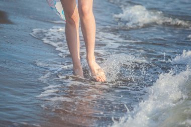 Bir kadının çıplak ayak bir kumsalda yürüyen closeup. Seyahat, tatil kavramı.