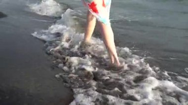 Güzel kadın bacakları, sahilde yürüyor.