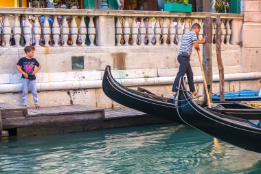 Venice, İtalya - 15.08.2018: Geleneksel gondol Venedik renkli tarihi evler arasındaki dar kanal.