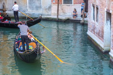 Venice, İtalya - 15.08.2018: Geleneksel gondol Venedik renkli tarihi evler arasındaki dar kanal.