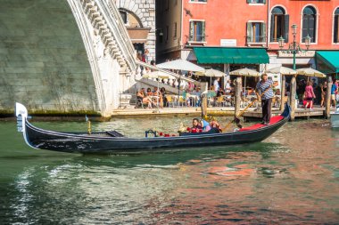 Venice, İtalya - 15.08.2018: Geleneksel gondol Venedik renkli tarihi evler arasındaki dar kanal.