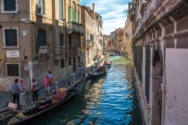 Venice, İtalya - 15.08.2018: Geleneksel gondol Venedik renkli tarihi evler arasındaki dar kanal.