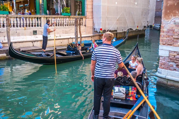 Venice, İtalya - 15.08.2018: Geleneksel gondol Venedik renkli tarihi evler arasındaki dar kanal.