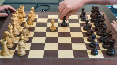 Ahşap satranç şekil bir satranç tahtası üzerinde hareketli el.