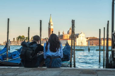 birkaç turist gondol Venedik, İtalya ile kanal başına oturmuş.