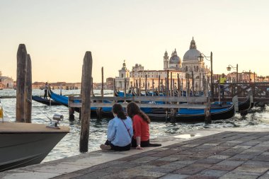birkaç turist gondol Venedik, İtalya ile kanal tarafından oturuyor. Santa maria della salute Kilisesi