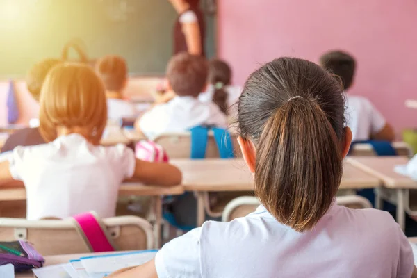 Grup oturan ve arkadan Öğretmen sınıfta dinleme okul çocuk.