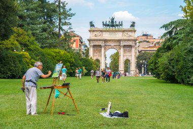 Milan, Italy - 14.08.2018: artist draws Arch of Peace in Sempione Park. clipart