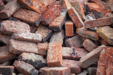 Eski kırmızı inşaat tuğla yığınları yere dağılmış.