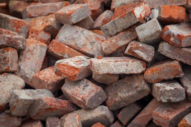 Eski kırmızı inşaat tuğla yığınları yere dağılmış.