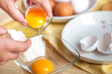 Kadın el, yumurta beyazı ve sarısı ayırmak için bir yumurta kırma arka plan yumurta kabukları.