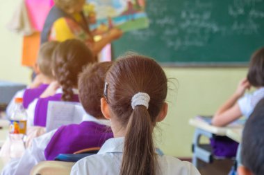 Eğitim, İlköğretim Okulu, oturma ve Öğretmen sınıfta dinleme okul çocuklar Grup.