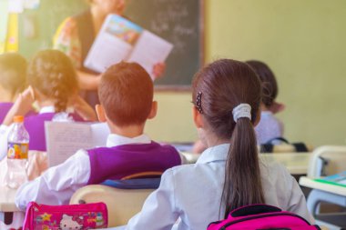 Eğitim, İlköğretim Okulu, oturma ve Öğretmen sınıfta dinleme okul çocuklar Grup.