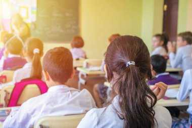 Eğitim, İlköğretim Okulu, oturma ve Öğretmen sınıfta dinleme okul çocuklar Grup.