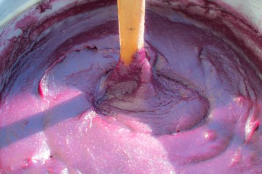 Üzüm suyu, Mısır ve pelamushi, tatara veya cevizli sucuk - tahta kaşıkla karıştırma büyük pot kazan içinde beyaz un ceviz veya fındık ile geleneksel Gürcü tatlı tatlılar yemek.