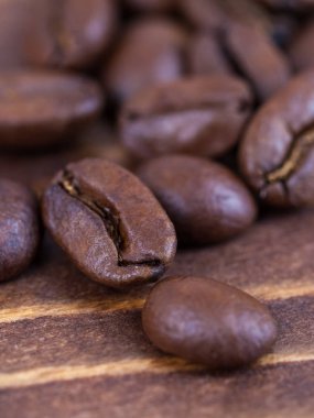 Ahşap bir masa üzerinde kavrulmuş kahve beens yakın çekim.