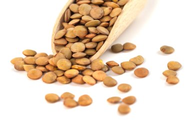 tahta kaşık beyaz bir arka plan üzerinde izole üzerinde kuru mercimek.