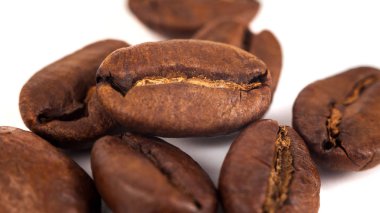 Kızarmış kahve çekirdekleri beyaz arka planda izole edilmiş..