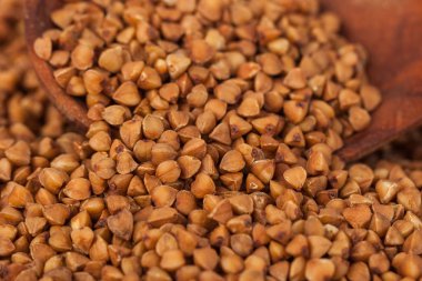 Bir tahta kaşık, sağlıklı gıda, karabuğday kabuğu çıkarılmış tane grup.