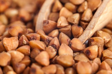 Bir tahta kaşık, sağlıklı gıda, karabuğday kabuğu çıkarılmış tane grup.