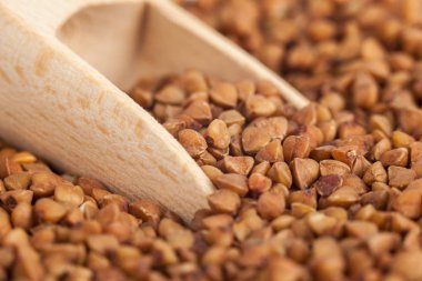 Bir tahta kaşık, sağlıklı gıda, karabuğday kabuğu çıkarılmış tane grup.