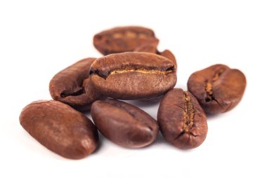 Kızarmış kahve çekirdekleri beyaz arka planda izole edilmiş..