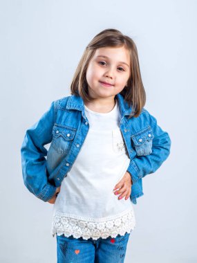 küçük kız stüdyoda kamera için poz kot pantolon.