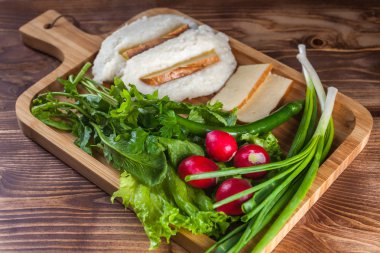 Mengrelian Mısır mamalica (ghomi) ile peynir ve ahşap masa üzerinde çeşitli bitki. Gürcü geleneksel gıda.