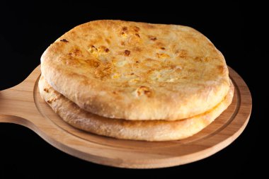 Gürcü geleneksel gıda khachapuri ahşap tabak siyah arka plan üzerinde üzerinde.
