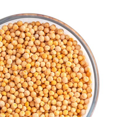 Beyaz arka plan üzerinde cam kase bezelye tohumları.