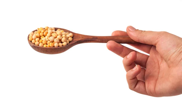 白い背景の上の黄色のエンドウ豆を手でスプーン — ストック写真