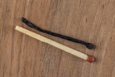 İki bir yanık eşleşir ve diğer yanmamış ahşap arka plan üzerinde izole.